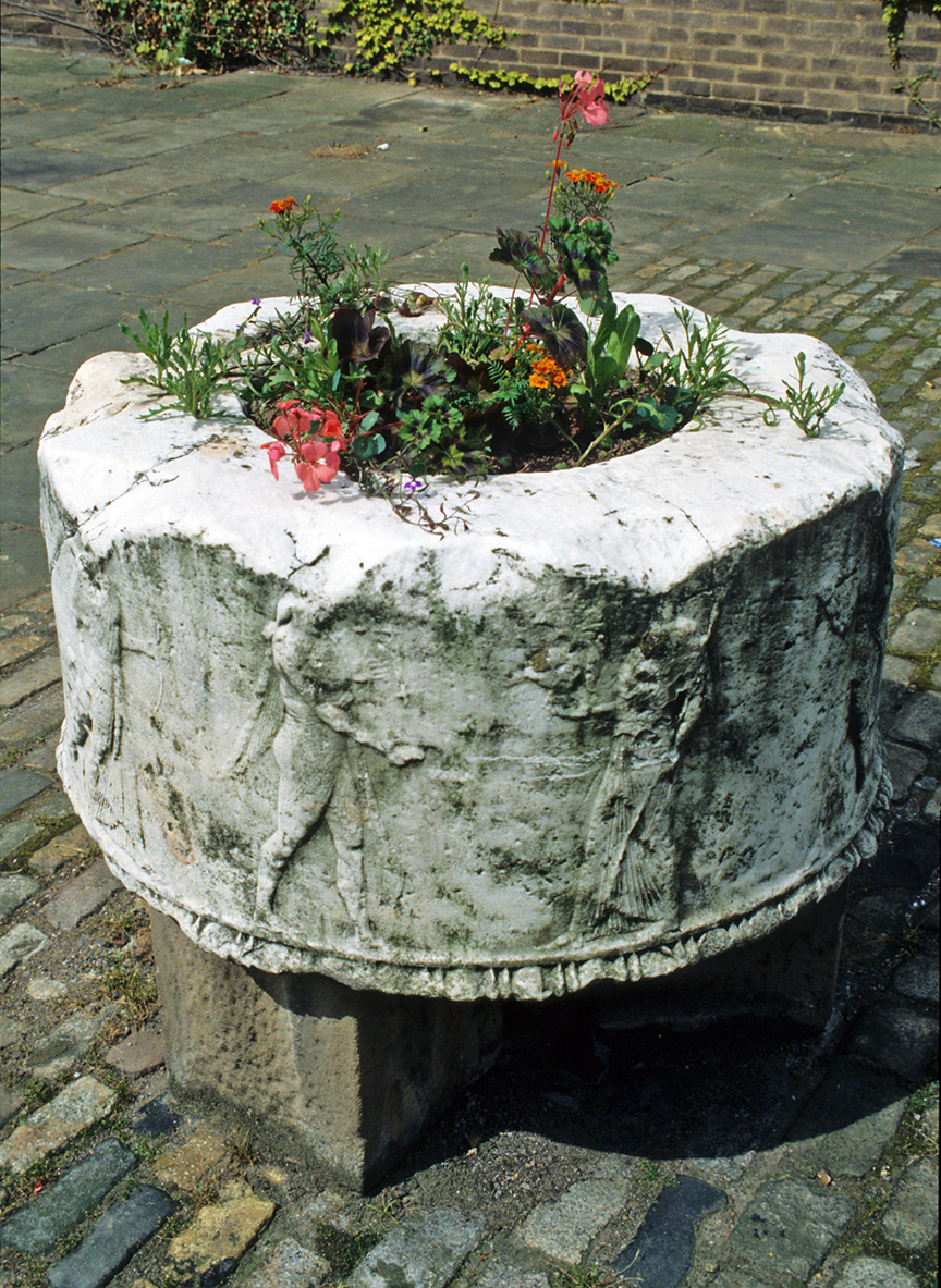 The Corinth Puteal at Bretton Hall Summer service as a plant pot. Photograph by David Hill, taken summer 1993.
